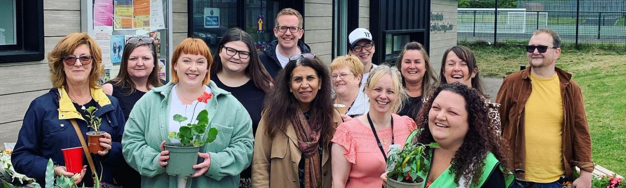 Carbrain community members pictured together with plants outside community centre