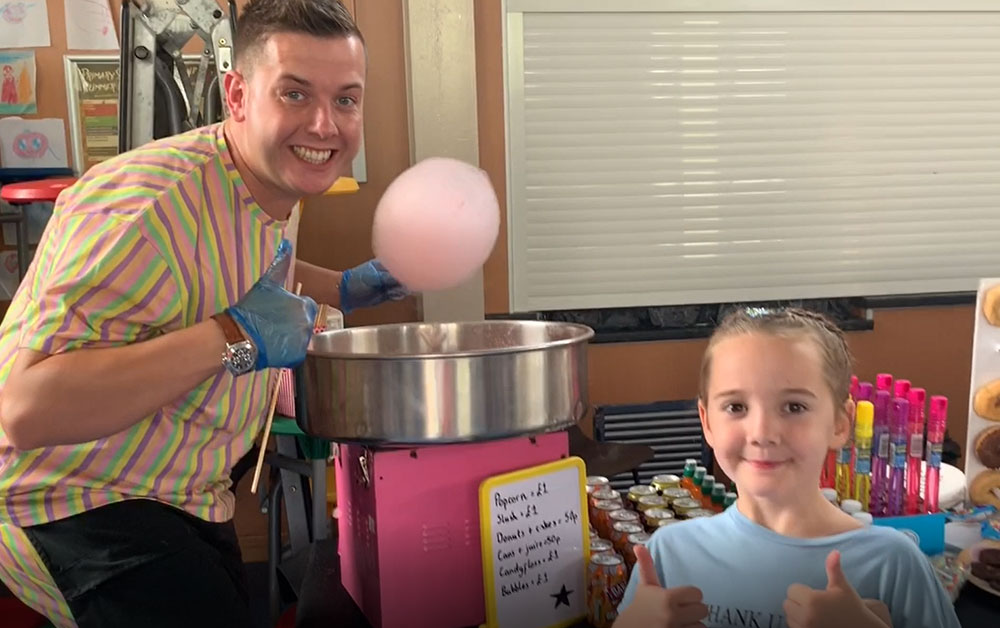 Adult and child making candy floss as part of the Carbrain Gala Day