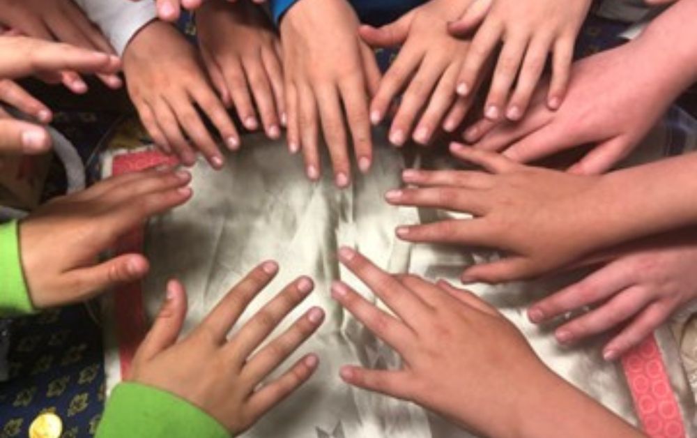 children's hands all facing towards the middle