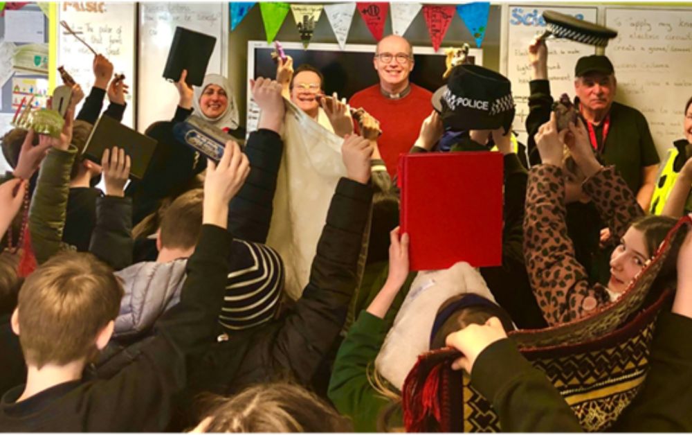 children with hands up in a school setting