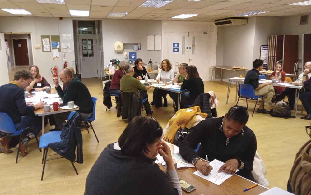 Group of people chatting at different tables and writing