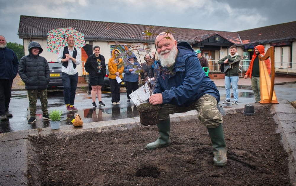 group of adults planting trees at a community centre
