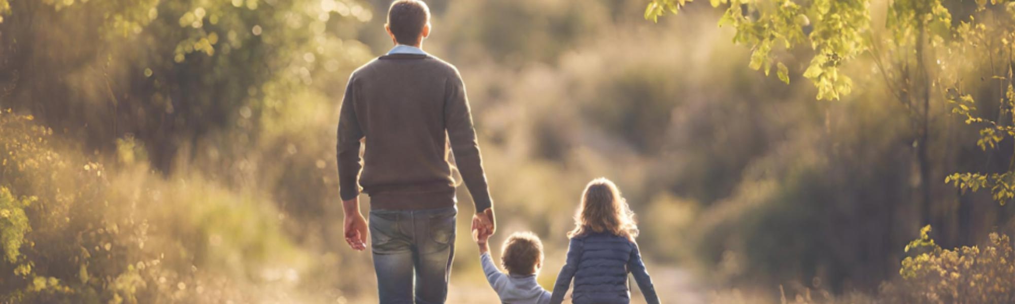Man walking holding hands with two children